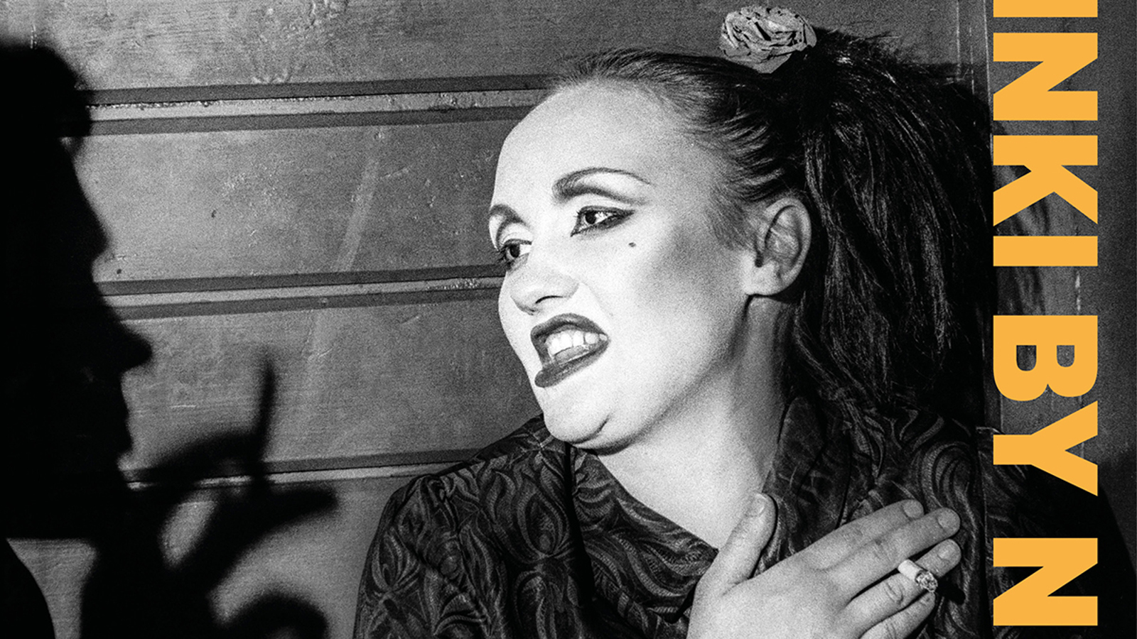 Kuvassa on nainen puolivartalokuvassa pää ja katse käännettynä vasemmalle oikeassa kädessään tupakka. Vasemmassa reunassa on miehen profiili ja kädessä tupakka. Oikeassa reunassa on pystysuorassa NKI BY N. Kuva on musta-valkoinen ja osa kirjan kantta.