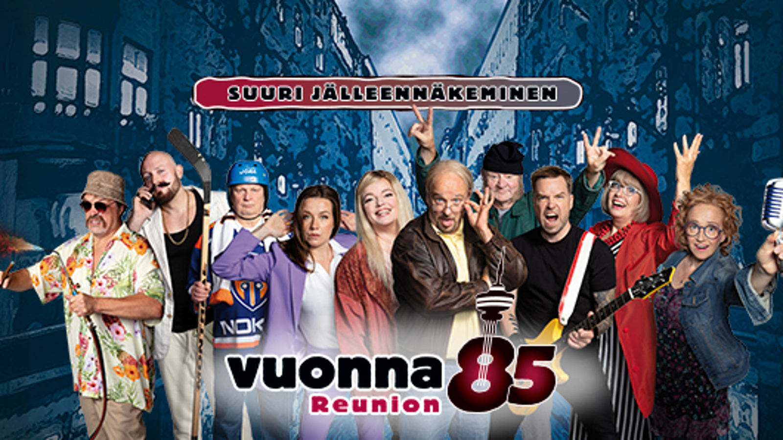 Kuvassa on yksitoista näyttelijää rivissä kesävaatteita. Yläpuolella on kyltti Suuri jälleenrakennus. Taustalla on tumman sinisiä rakennuksia.   