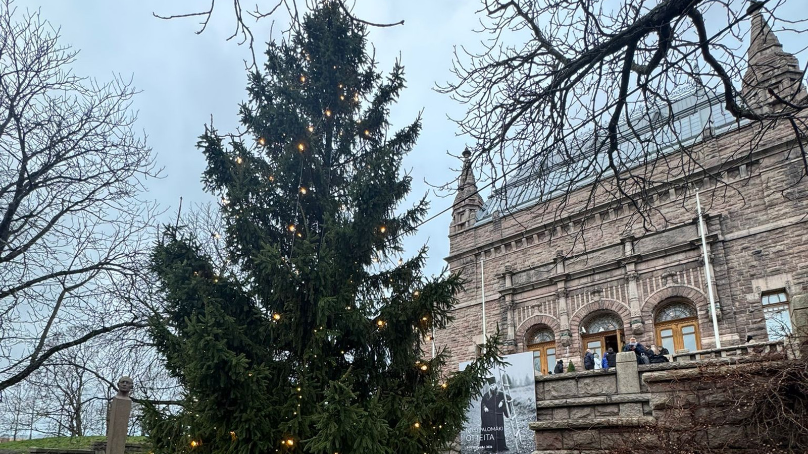 Kuvassa Turun taidemuseon päärakennus, joka on ruskea kivirakennus, jossa on kaksi pientä tornia. Vasemmalla keskellä on suuri kuusi.