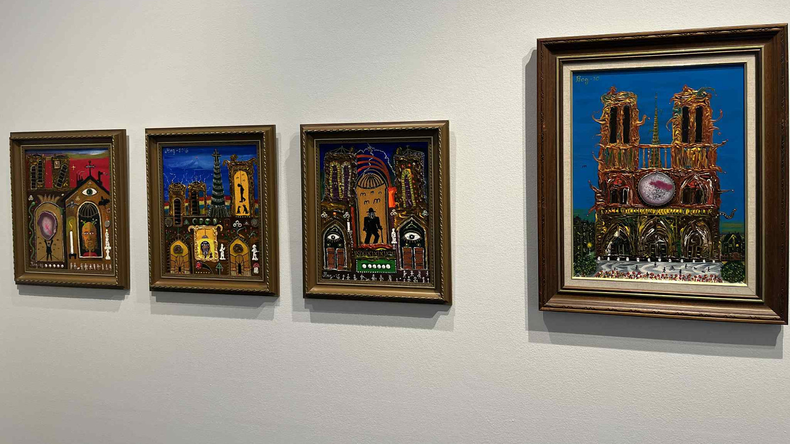 Kuvassa on vasemmalla on kolme pienempää taulua ja yksi iso. Niissä on tumman ruskeaa ja kirkasvärisiä kohtia. Oikealla on iso taulu, jossa on Notre Damen näköinen rakennus kahdella tornilla.