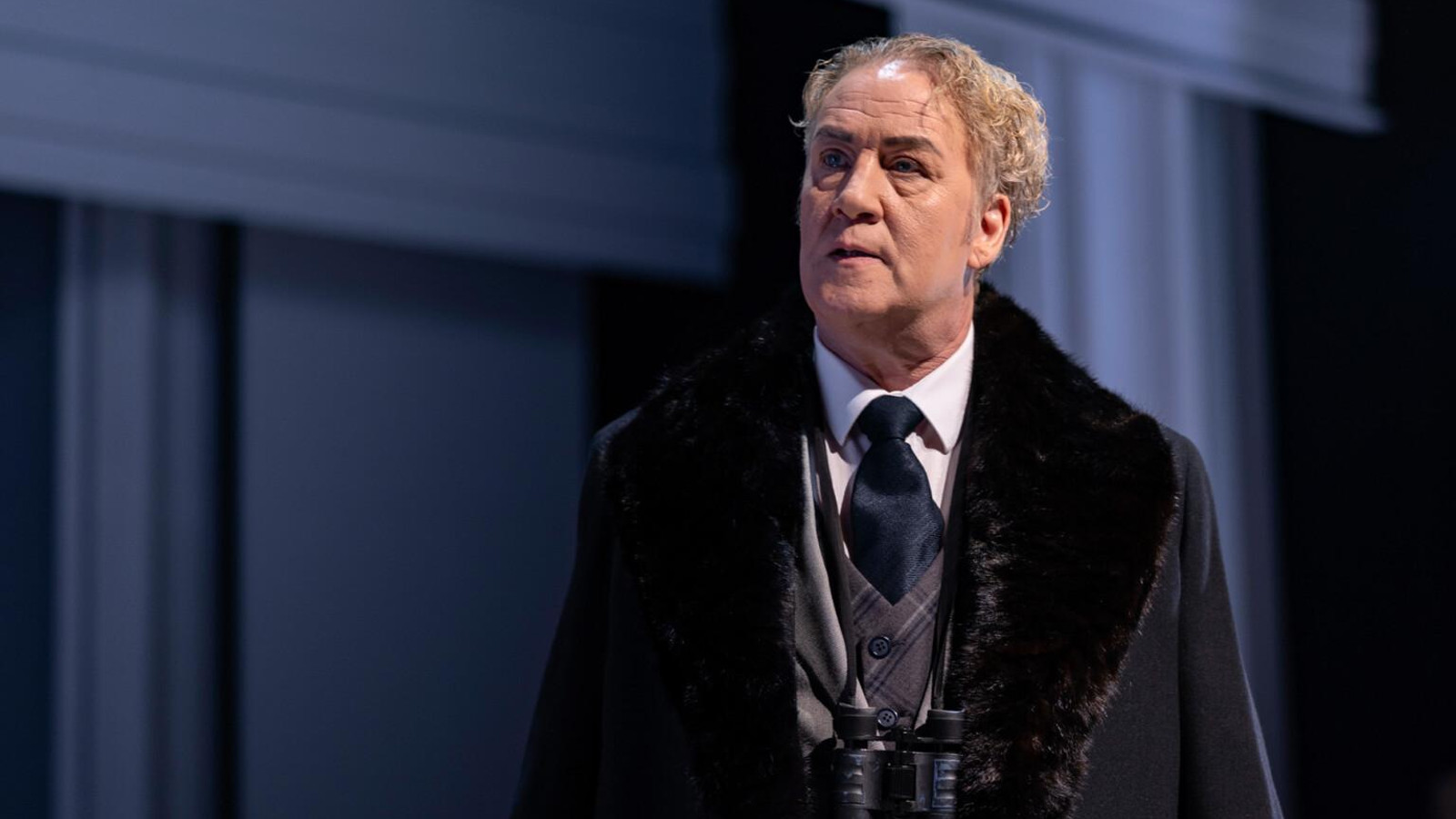 Kuvassa on Jarkko Sarjanen seisomassa puolivartalokuvassa. Hänellä on tumma ulsteri ja sen alla harmaa liivi sekä tumma kravatti. Taustalla on tumman sinistä.