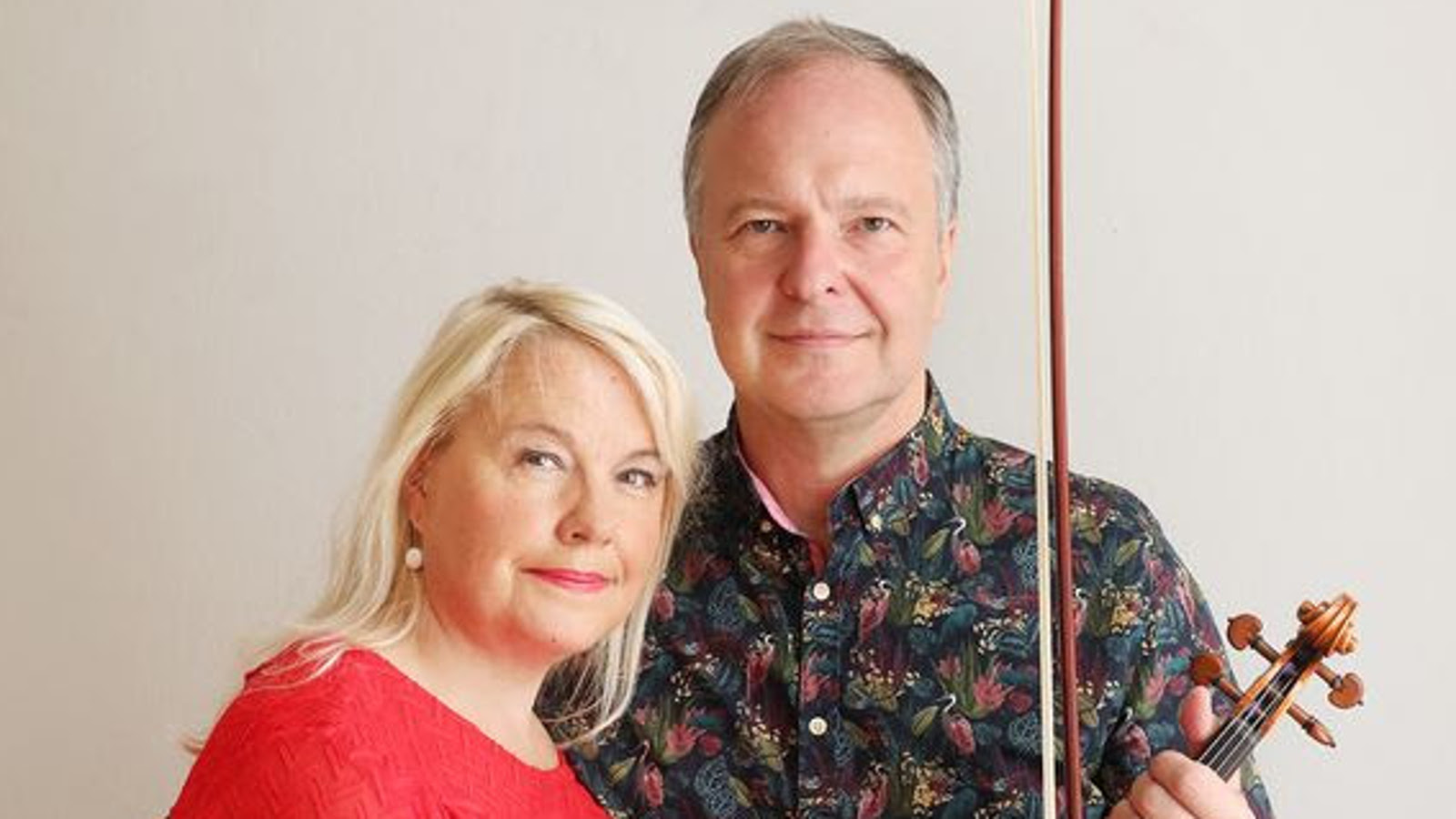 Kuvassa ovat puolivartalokuvassa Anu Komsi punaisessa puserossa ja Sakari Oramo tumman kirjavassa paidassa. Tausta on vaalea.