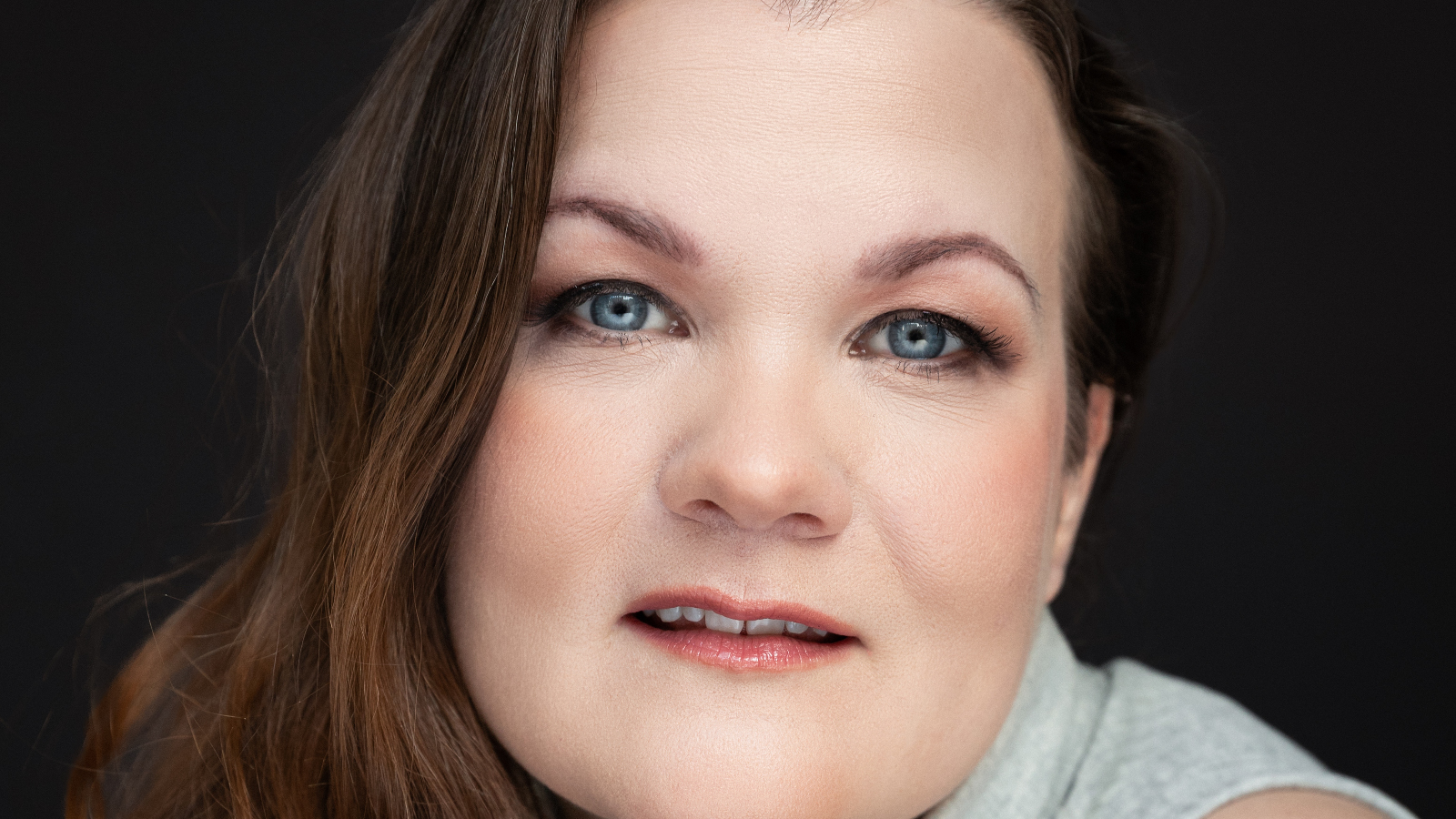 Kuvassa on Marika Huomolin kasvokuvassa. Hänellä on pitkät, ruskeat hiukset.