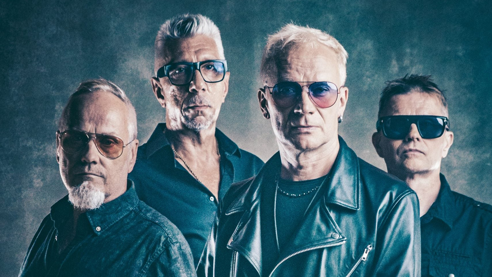 Kuvassa on Neljän Ruusun neljä miestä puolivaralokuvassa. Heillä on mustat nahkatakit päällään. Kasvot ovat punertavat ja tausta sekä kuvan sävy on harmaan sininen.