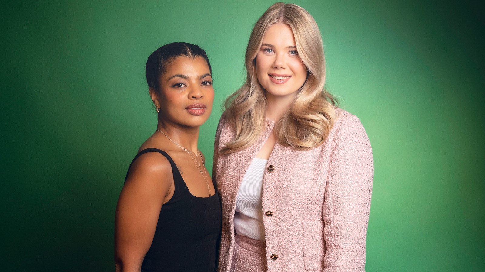 Kuvassa on vasemmalla Yasmine Yamajako mustassa hihattomassa t-paidassa. Hänen vieressään oikealla seisää vaalean punaisessa jakussa Nomi Enckell. Tausta on vihreä.