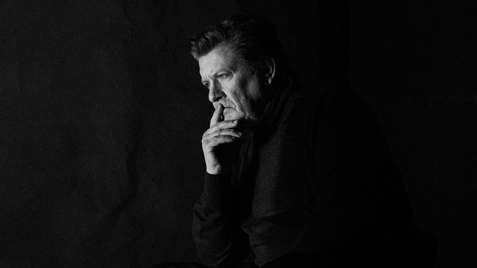 Kuvassa on keskellä Santeri Kinnusen kasvot ja käsi, joka nojaa poskeen. Kuvan tausta on musta ja kuva on musta-valkoinen.