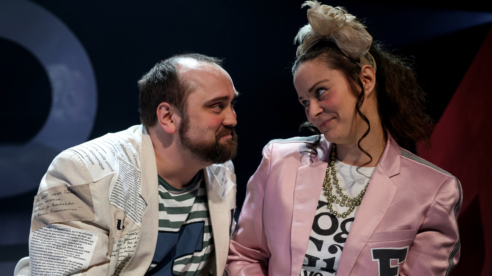 Kuvassa on vaaleassa takissa istumassa Sami Saino ja oikealla Satu Turunen vaalean punaisessa takissa ja kirjavassa t-paidassa. He ovat puolivartalokuvassa.