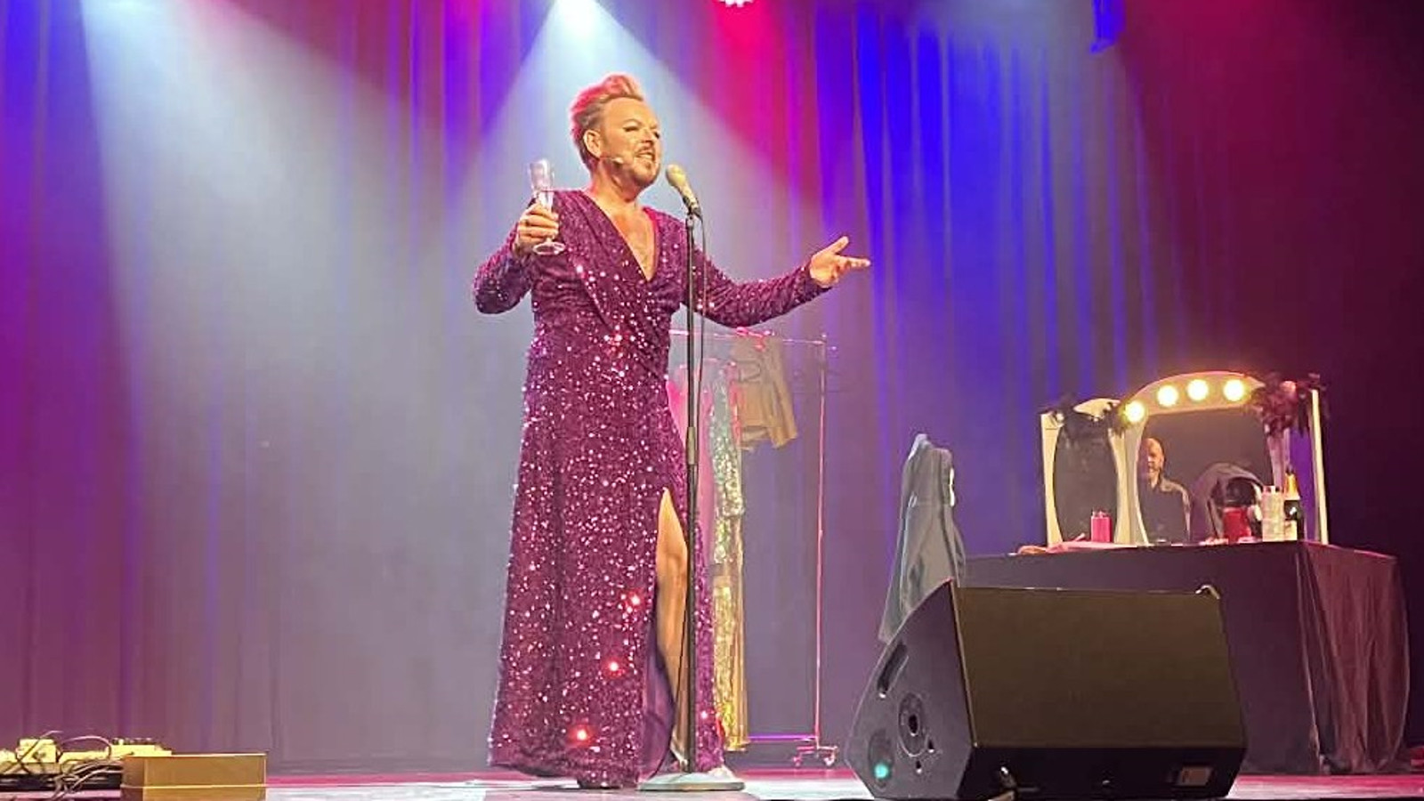 Kuvassa on vasemmalla Iiro Ollila soittamassa kitaraa. Mika Tepsällä oikealla laulamassa punaisessa, hihattomassa puserossa ja pitkissähousuissa.  Taustalla on vaaterekki. Taustalla on sinistä ja vihertävään verhoa.