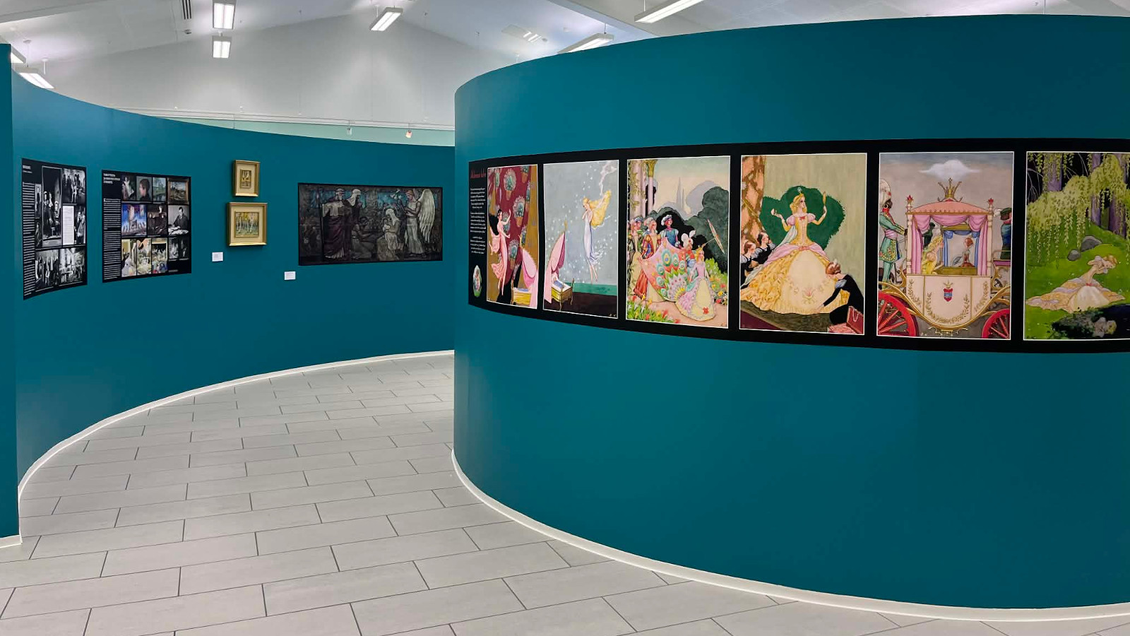 Kuvassa on sinistä pyöreätä seinämää ja vasemmalla kaartavaa seinää. Seinillä on Rudolf Koivun värikkäitä kuvituskuvia.