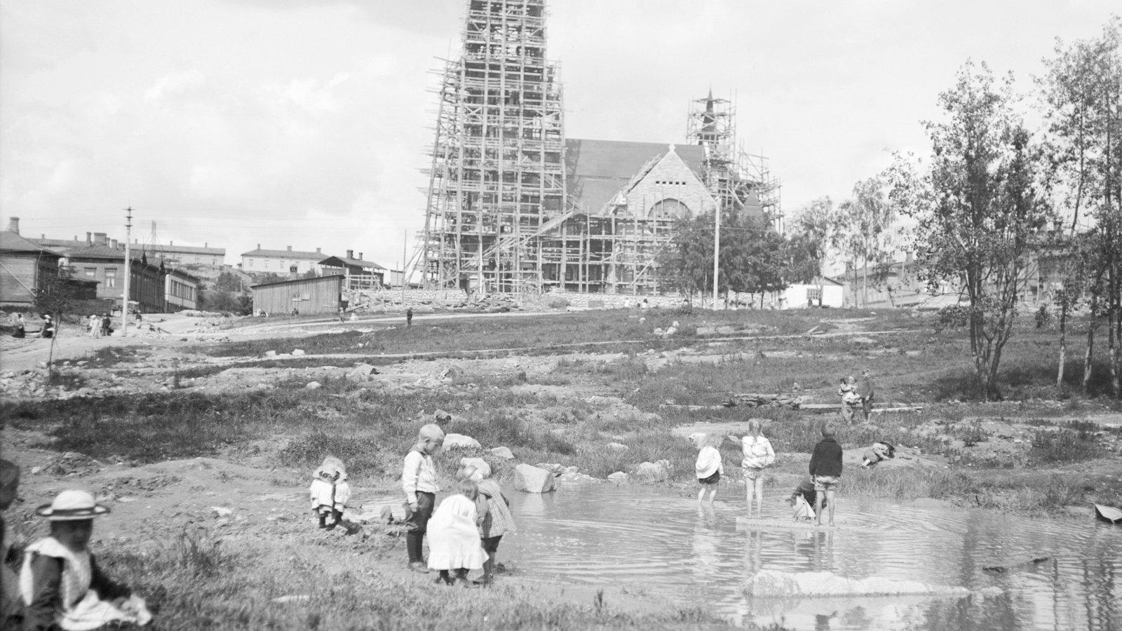 Samoihin aikoihin vuonna 1899, kun Venäjän keisari Nikolai II julkaisi Suomen perustuslakia loukkaavan helmikuun manifestin, suunniteltiin myös Juhannuskylään Johanneksen kirkkoa (Tuomiokirkkoa). Kirkon rakennustyöt aloitettiin vuonna 1902, ja se valmistui keväällä 1907. Uusi suomalainen kirkko toi vastapainon kosken itäpuolen kaupunkikuvaa siihen asti hallinneelle ortodoksikirkolle. Kuva: Werner Mauritz Gestrin / Vapriikin kuva-arkisto