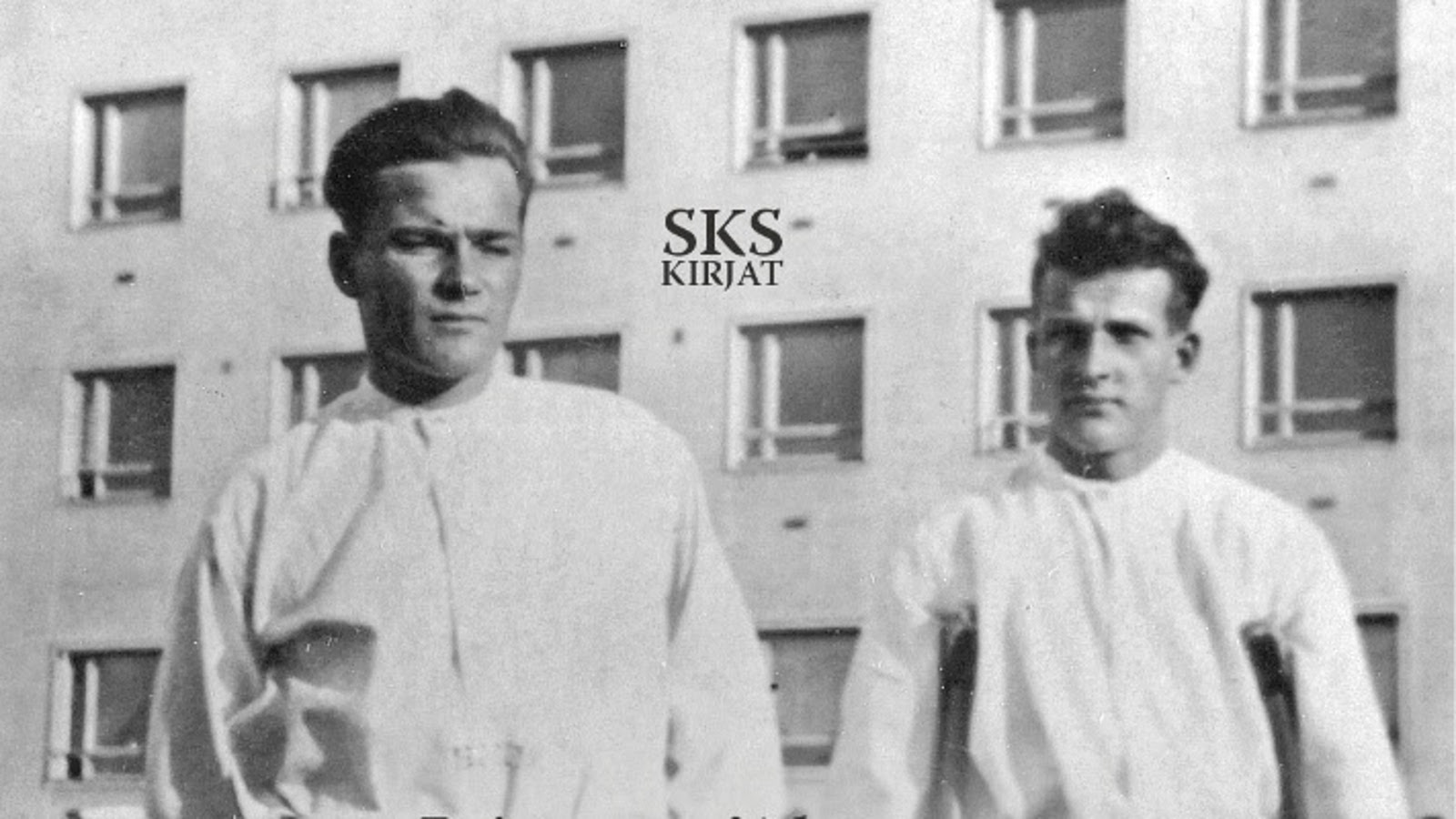 Kuvassa on kaksi miestä puolivartalokuvassa valkoisissa paidoissa sairaalarakennuksen edessä, jossa on paljon ikkunoita. Oikean puoleisella on puiset kainalosauvat kainaloissaan. Kuva on musta-valkoinen. Kuva on osa kirjan kannesta.