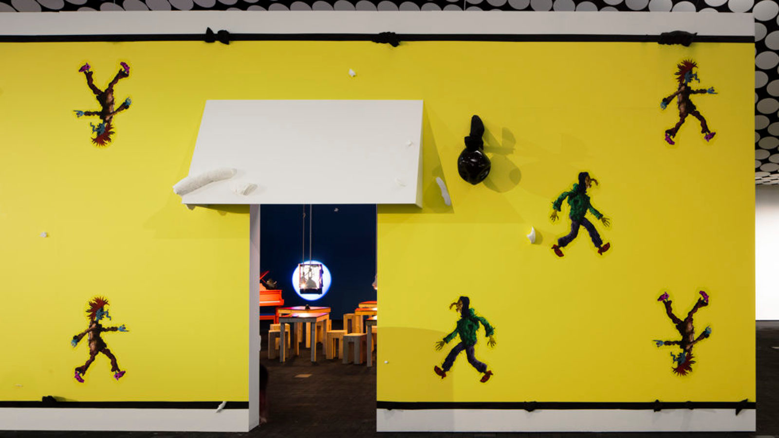 Kuva on osa Ars Fennica -näyttelyä Amos Rexissä.  Kuvassa on voimakkaan keltaisella pohjalla käveleviä hahmoja, joista kaksi kävelee pää alaspäivä ja toiset vastakkaisiin suuntiin. Keskellä on valkoisen markiisiulokkeen kuva ja sen alla oviaukko, josta näkyy Aalto-huonekalujen näköisiä tuoleja ja pöytä.  