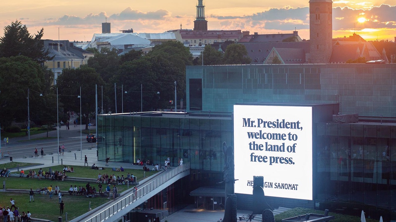 Kuvassa on Musiikkitalo, jonka seinällä on iso lakana ja siinä lukee Mr. President, welcome to the land of free press.