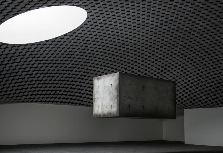 Kuva on Amos Rexin Studio Driftin ja Magritten näyttelystä.  Kuvassa on ylhäällä lähellä kattoa utopistinen, leijaileva valkoinen, soikea leijaleva betonielementti ja alempana neliskulmainen harmaa elementti.  Kuva on musta-valkoinen ja kuvaaja Stella Ojala.