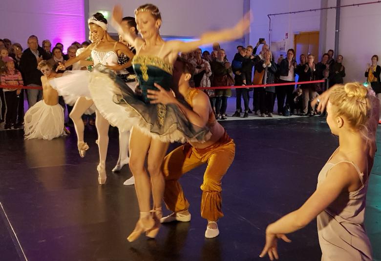 Kuvassa on etualalla katsomassa muita Katariina Luukas ja hänen vieressään turkoosissa balettipuvussa Elena Ilyina, jota nostaa Ilya Bolotov ruskeissa housuissa ja vaaleassa paidassa. Takana valkoisessa balettiasussa Valeria Quintana.  Taustalla yleisöä.
