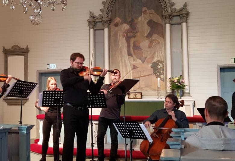 Kuva on Vivaldin Neljä vuodenaikaa konsertosta.  Kaikki esiintyjät ovat mustissa asuissa.  Vasemmalla soittaa viulua Jukka Merjanen, samoin taaempana Vivianne Stolt, edessä solisti Petteri Iivonen ja takana Ilari Angervo.  Alhaalla sellossa Samuli Peltonen.