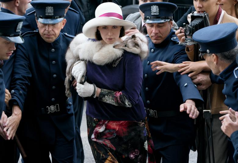 Kuvassa on Maria Åkerblom keskellä ja hän on kävelemässä sinipukuisten, koppalakkisten poliisien saattelema.  Marialla on päällään sininen jakku ja kukallinen puolihame.  Päässään hänellä on valkoinen lierihattu ja kaulassaan valkoinen turkispuuhka.