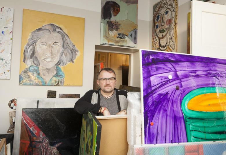 Kuvassa on Seppo Fränti keskellä kuvaa lahjoittamiensa taulujen keskellä.  Fräntistä näkyy ylävartalo ja hänellä on päällää villatakki, joka on msuta-harmaa sekä harmaa paita.  Hänellä on silmälasit ja hiuksia päälaella.  Takana on seinällä taulu, jossa on naisen pää vaalean keltaisella taustalla ja hiusten sekä kasvojen väri on harmaa.  Edessä oikealla on taulu, jossa on liloja juovia ja keskellä keltainen rinkula vihreän rinkulapinon keskellä. Huoneessa on lisää tauluja lähdössä Kiasmaan.