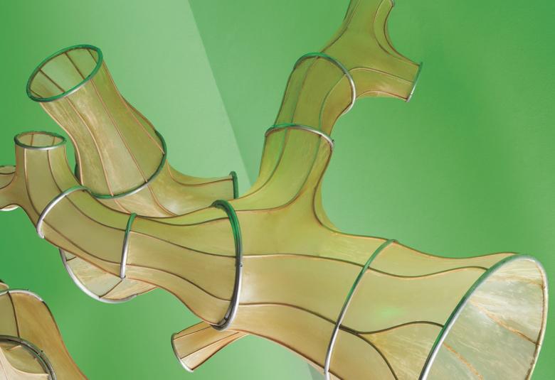 Kuvassa on Julia Lohmanin installaatio Okinaganode sculpture, jossa vaalean vihreällä pohjalla kelluu vaalean ruskeita putkilomaisia teoksia. Pinnassa on muutamia renkaita ja pituussuuntaisia juovia.