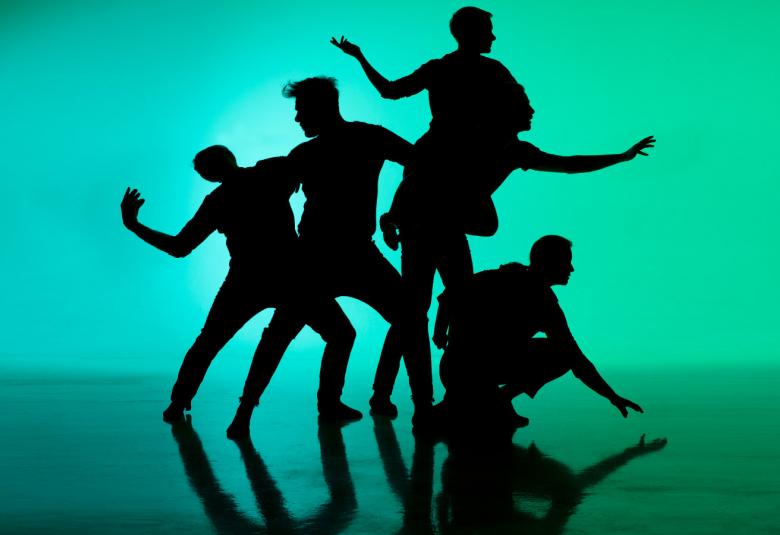 Kuvassa on viiden miestanssijan ryhmä ja kuvassa on vihreä tausta. Tanssijat kurottavat eri suuntiin.