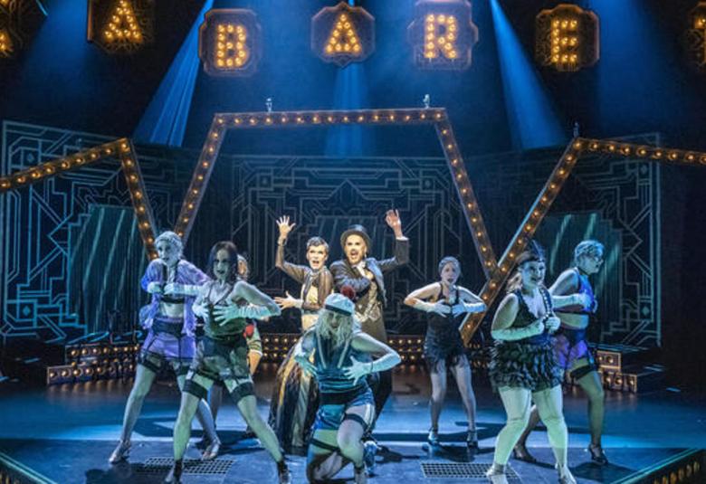 Kuvassa on sinisävyisellä taustalla Cabaretin esiintyjät näyttämöllä ja taustalla sininen tausta sekä ylhäällä nimi Cabaret.