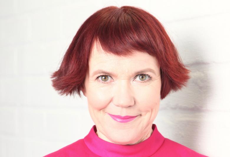 Kuvassa on Rosa Liksom, jolla on punainen polkkatukka.