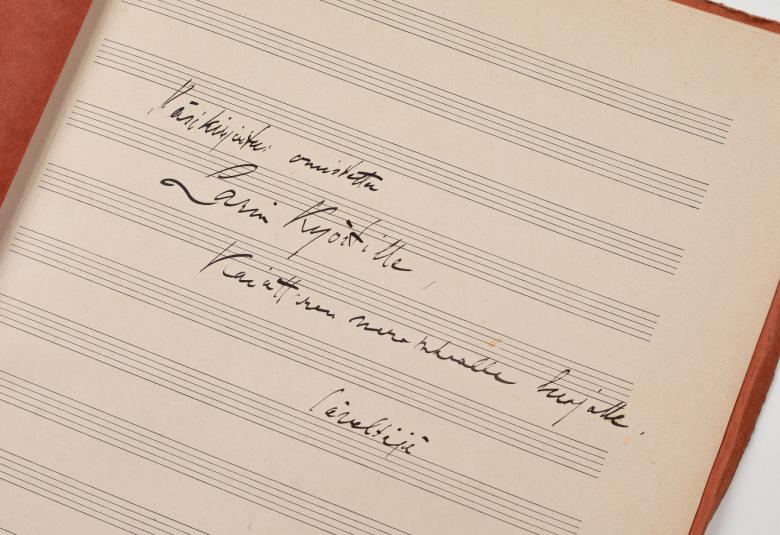 Kuvassa on sivu, jossa lukee Sibeliuksen omistuskirjoitus: Käsikirjoitus on omistettu Larin Köstille, Kaiuttaren nerokkaalle luojalle. Säveltäjä.