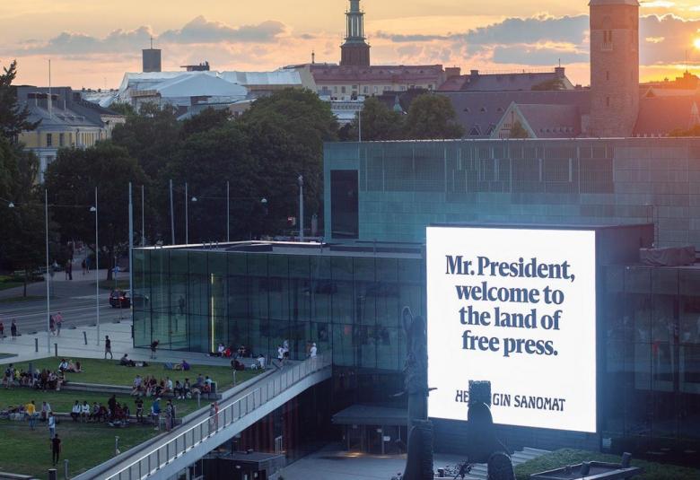 Kuvassa on Musiikkitalo, jonka seinällä on iso lakana ja siinä lukee Mr. President, welcome to the land of free press.