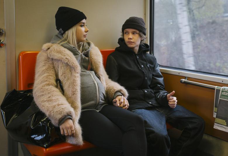 Kuvassa on elokuvan Hölmö nuori sydän päähenkilöt Rosa Honkonen ja Jere Ristseppä.  He ovat lähijunassa ja molemmat ovat nuoria henkilöitä. Tyttö on raskaana.