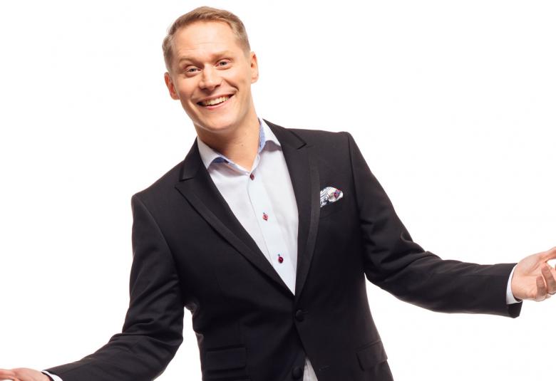 Kuvassa on Jawrkko Tamminen sinisessä takissa ja kädet ojennettuina avoimesti.