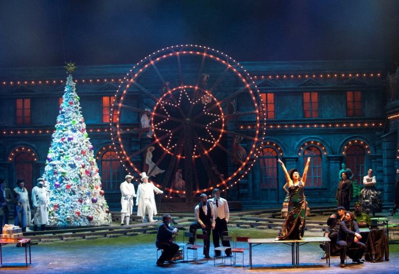 Kuvassa on italialainen tori ja takana on valaistu maailmanpyörän näköinen elementti ja  vasemmalla valkoinen joulukuusi.  Esiintyjät ovat etualalla.