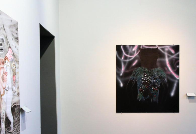 Kuvassa on kaksi Hannaleena Heiskan taulua, joista toinen on vasemmalla seinällä vinosti ja on vaaleasävyinen.  Kuvassa suoraan nähtävissä on tumma sävyinen pienempi taulu.