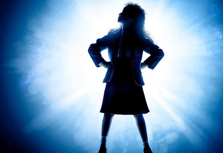 Kuvassa on Matilda-musikaalin julisteesta tytön hahmo ja se on reunalta sininen.  Tytön hahmo on musta ja ympärillä on valkoista valoa. 