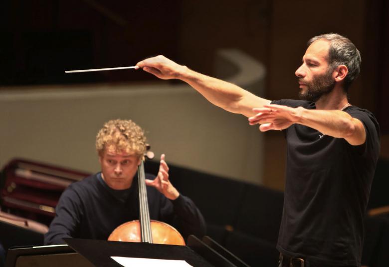 Kuvassa Dima Slobodeniouk johtamassa Sinfonia Lahtea. Kuvassa näkyy muutama soittaja ja kapellimestari.