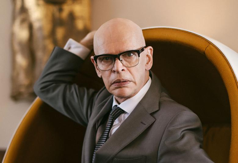 Kuvassa Jorma Uotinen Kekkosena istumassa pallotuolissa kekkosmaiset silmälasit päässään ja puku päällä.