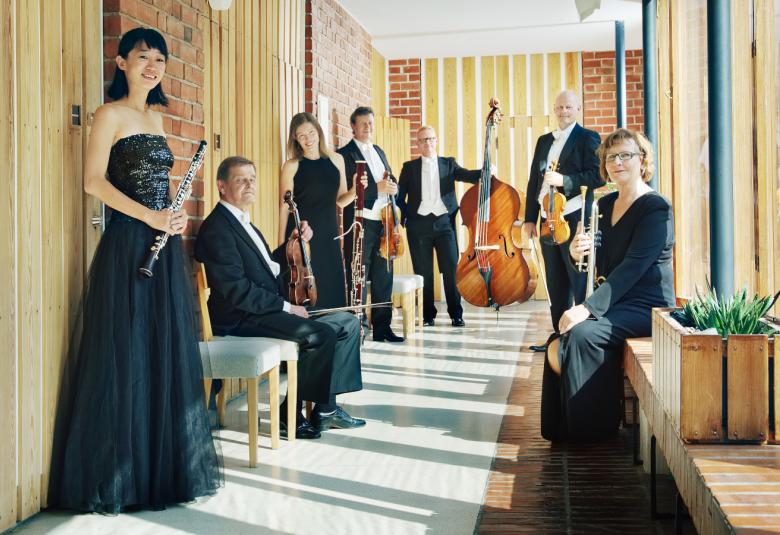 Kuvassa on Jyväskylä Sinfonia käytävätilassa ja soittajat ovat molemmin puolin käytävää rivissä.