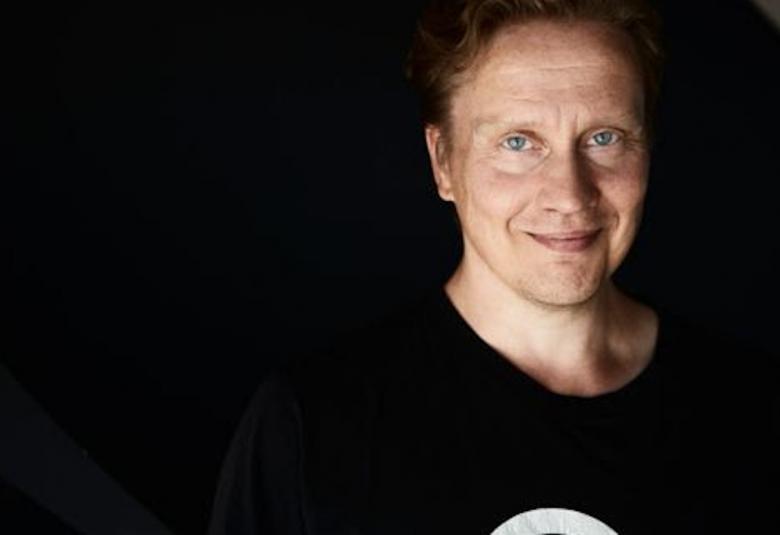 Kuvassa on Teemu Mäki ja kuvasta vasen puoli on musta.  Toisessa reunassa on Mäen kasvot tummalla pohjalla.