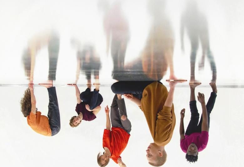 Kuvassa on tanssijoita niin, että alla olevat ovat väärin päin ja heijastuvat ylöspäin puolivälissä olevan lattian kautta.  Tausta on valkoinen.