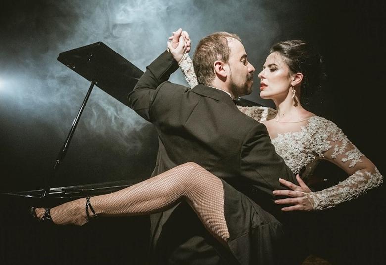 Kuvassa on tanssijat Christina Sosa ja Daniel Nacuccio ja kuva on puolivartalokuva.  Tanssijat ovat asennossa, jossa Sosalla on jalka ylhäällä ja Nacuccio pitää sitä kädessään.