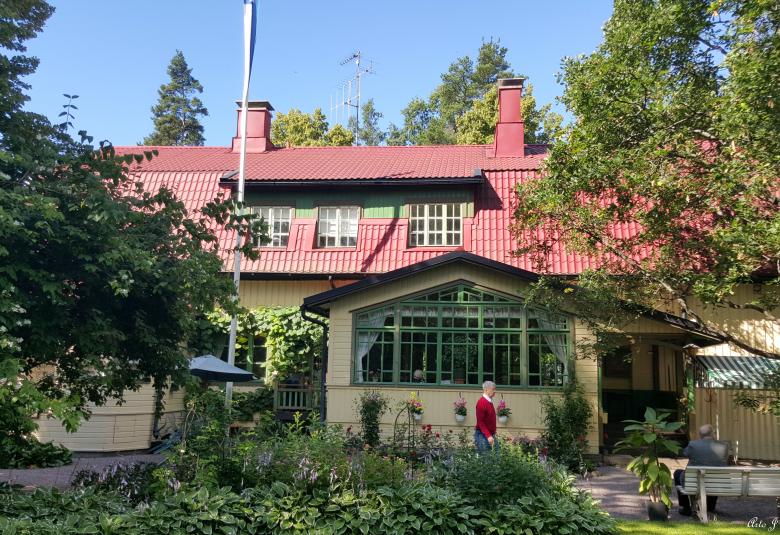 Kuvassa on mansardikattoinen Järnefeltien talo Suviranta.  Sen puutarha on etualalla ja talo näkyy taaempana.  Kuva on otettu kesällä.