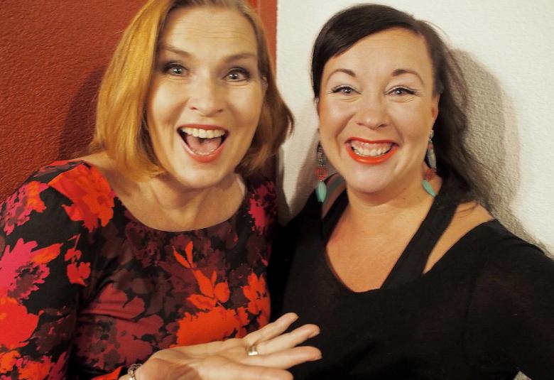 Kuvassa on vasemmalla Sari Havas ja oikealla Pauliina Hukkanen, joista on puolivartalokuva.  Molemmilla on iloiset ilmeet.