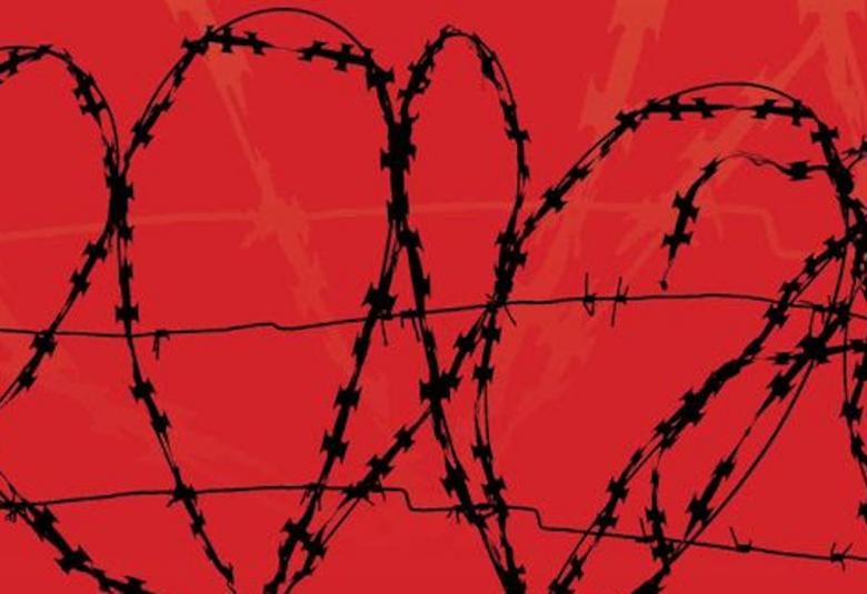 Kuvassa on punaisella pohjalla mustaa piikkilankaa.