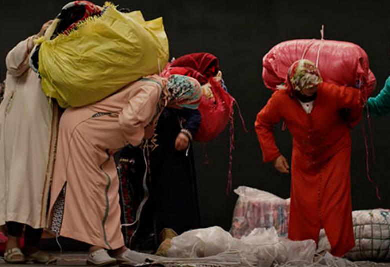 Kuvassa on afrikkalaisia naisia värikkäissä vaatteissa ja kantamuksia mukanaan.