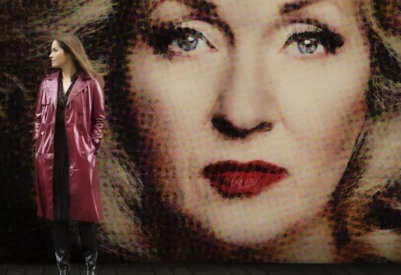 Kuvassa on isossa taustakuvassa on Katariina Kaituen kasvokuva ja vasemmalla seisoo sivuttain Annika Poijärvi.