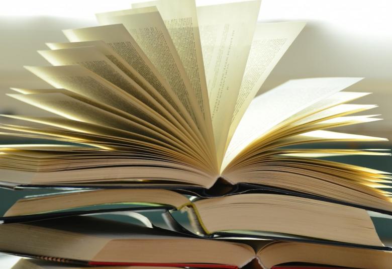 Kuvassa on neljä kuvaa päälekkäin ja ne ovat auki keskeltä.  Päälimmäinen on viuhkamaisesti auki.