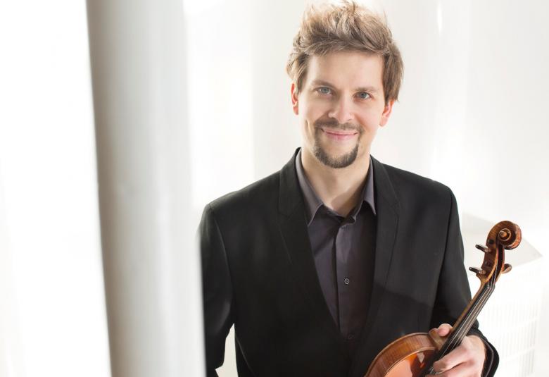 Kuvassa on Jukka Untamala viulu kädessään. Kuva on puolivartalokuva.