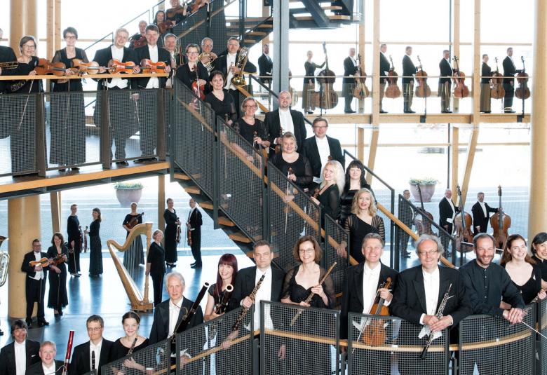 Kuvassa on Sinfonia Lahden soittajia Sibelius-talon postaikossa, joka mutkittelee talon aulatilassa.