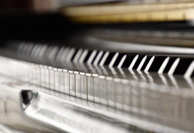 Kuvassa on pianon koskettimet kuvattuna koskettimien tasolta. Kuva on musta-valkoinen.