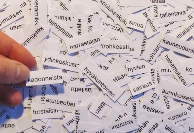 Kuvassa on paperinpaloja, joissa on sanoja.  