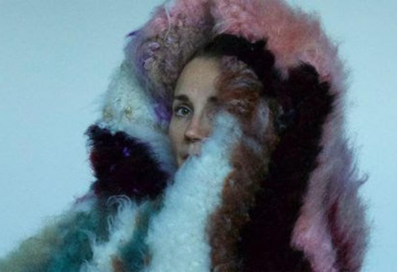 Kuvassa on Hannak-Kaisa Korolainen pääänsä ympärillä tekemäänsä tekstiilitaidetta turkismaisesti.